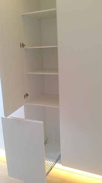 Mueble columna a medida lacado blanco con uñero. Tolva extraíble