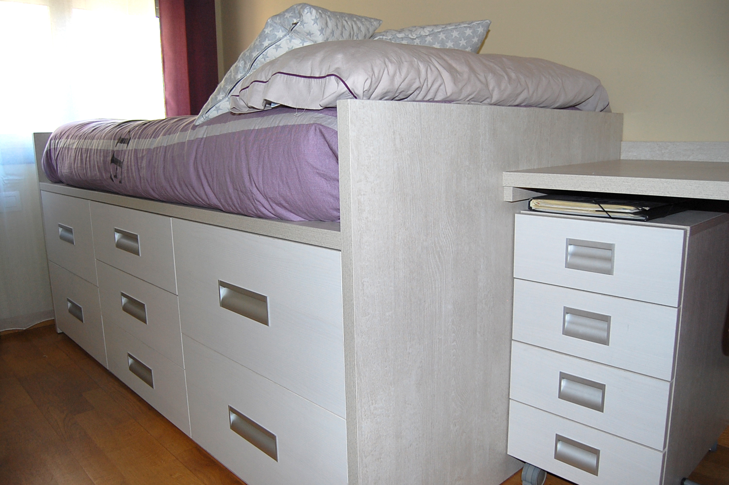 Dormitorio juvenil en melamina color compuesto por cama con cajones de extracción total con freno, escritorio y librería