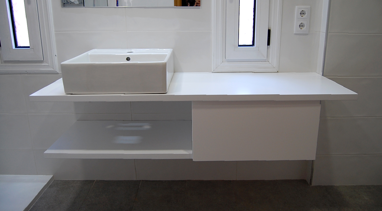 Mueble de baño a medida suspendido lacado blanco satinado con uñero. Encimera hidrófuga, cajón con guía de extracción total con freno y estante.